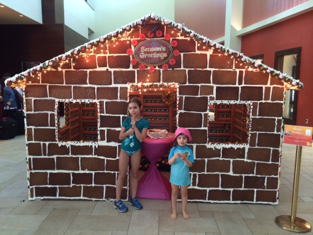 Guests posing at the life-size gingerbread house at the Aruba Marriott.JPG